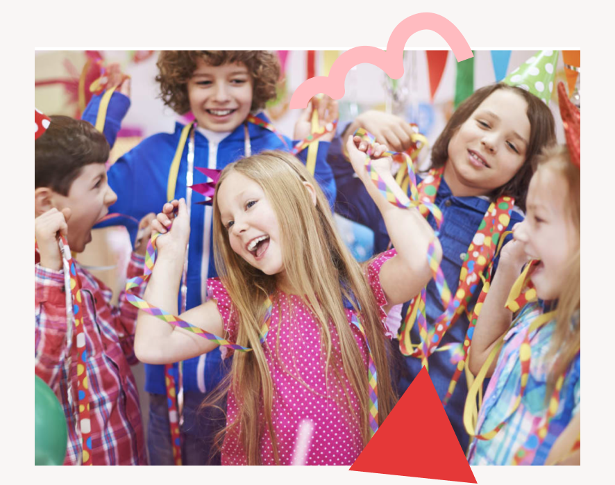 Un groupe d'enfants joyeux, portant des chapeaux de fête colorés, dansent joyeusement et tiennent des banderoles lors d'une fête festive. Ils rient et semblent s'amuser, entourés de décorations colorées.