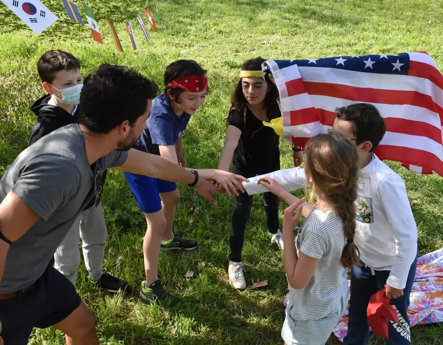 Un animateur Kidays mène un jeu avec des enfants dans un parc