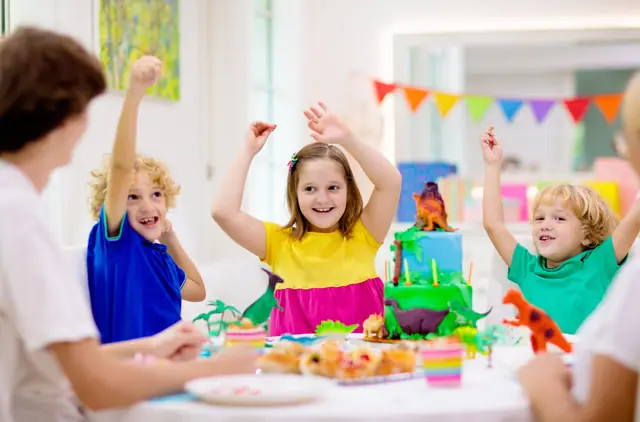 Des enfants fêtent un anniversaire Dinosaure autour de la table