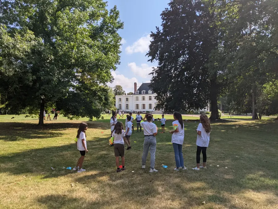 Des enfants jouent avec des animateurs Kidays dans le parc d’un château