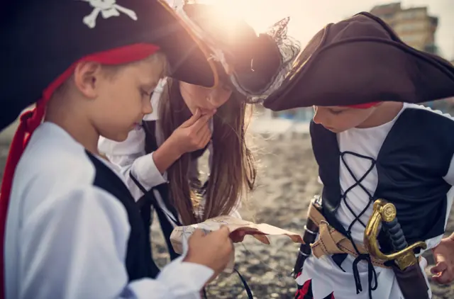 Des enfants pirates lisent une carte au trésor