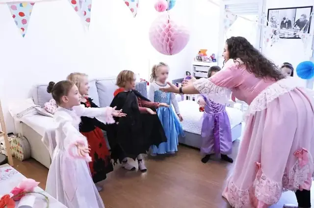 Une animatrice Kidays en robe de princesse danse avec des enfants