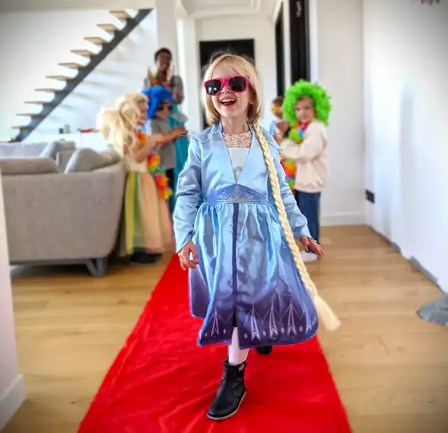 Une petite fille en robe de princesse défile