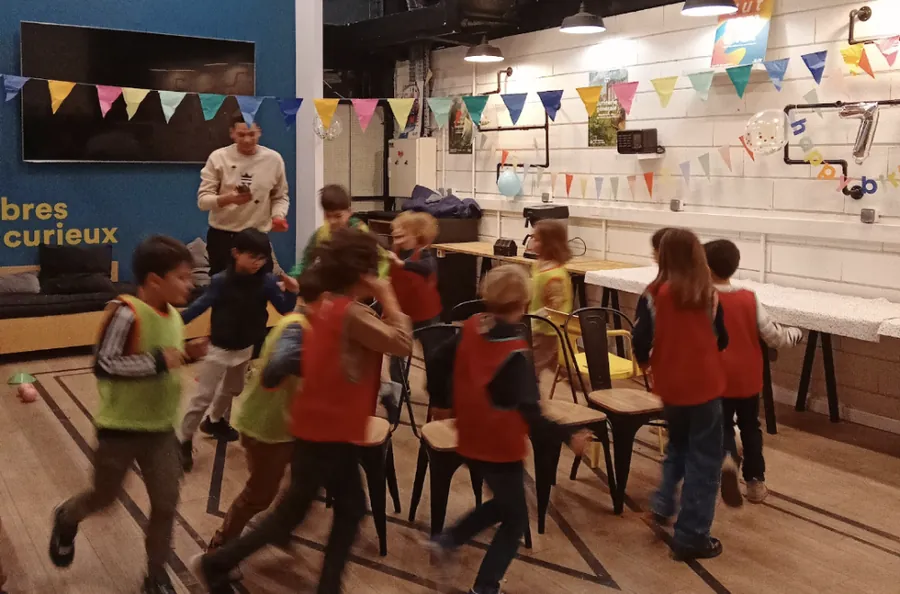 Des enfants jouent avec une animatrice Kidays dans une salle du Ground Control à Paris