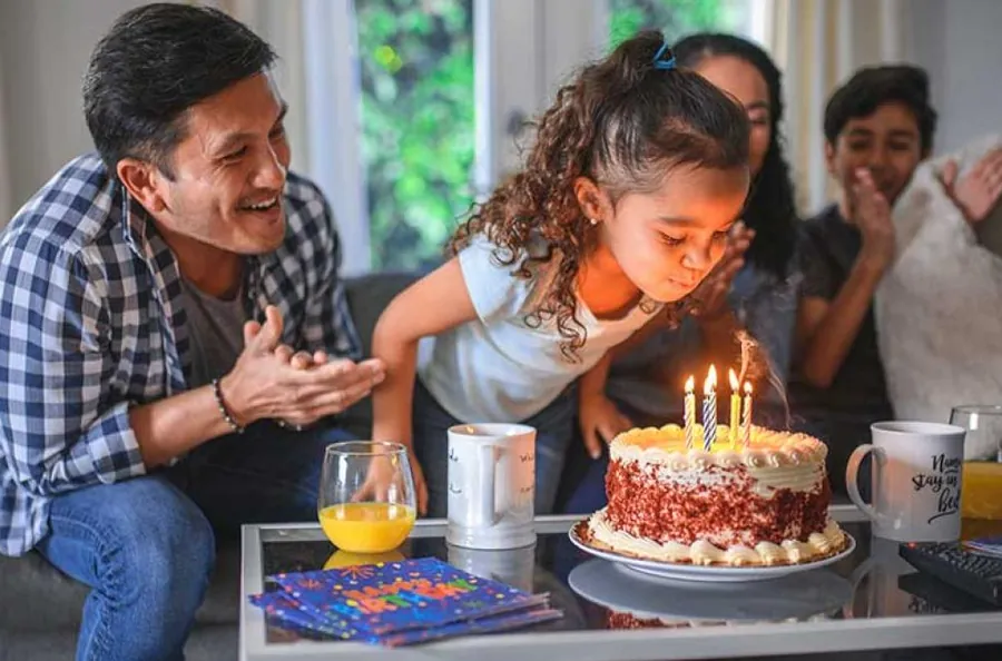 Une famille fête un anniversaire autour d’un gâteau