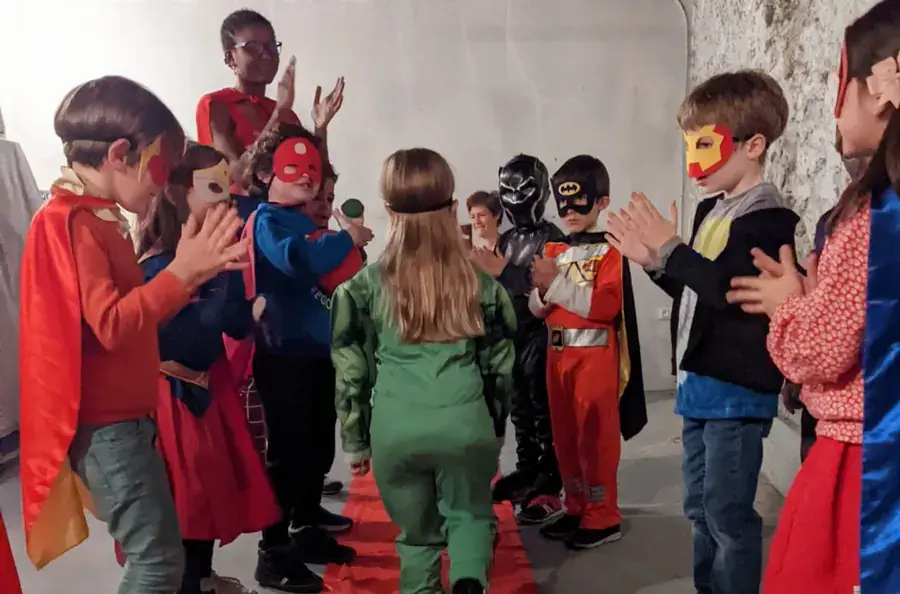 Des enfants masqués applaudissent pendant la fête