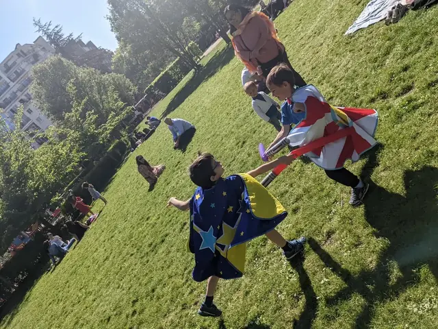 Des enfants en capes courent dans l’herbe