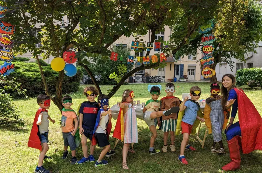 Des enfants en capes et masques de super-héros dans un jardin